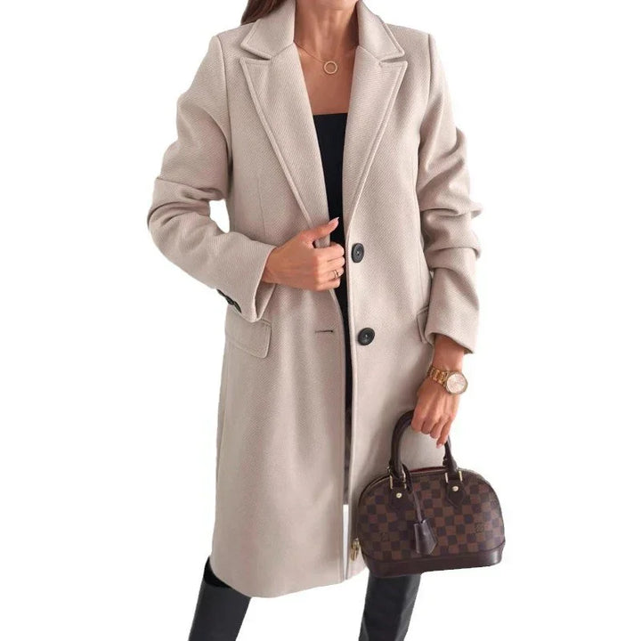 Woman wearing beige long coat, holding checkered brown handbag, Rovelli fashion style
