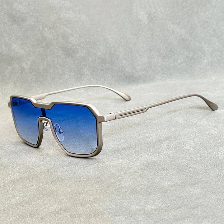 A pair of modern, geometric Heavy Metal Sunglasses with square metallic frames and blue gradient lenses rests on a light grey textured surface.