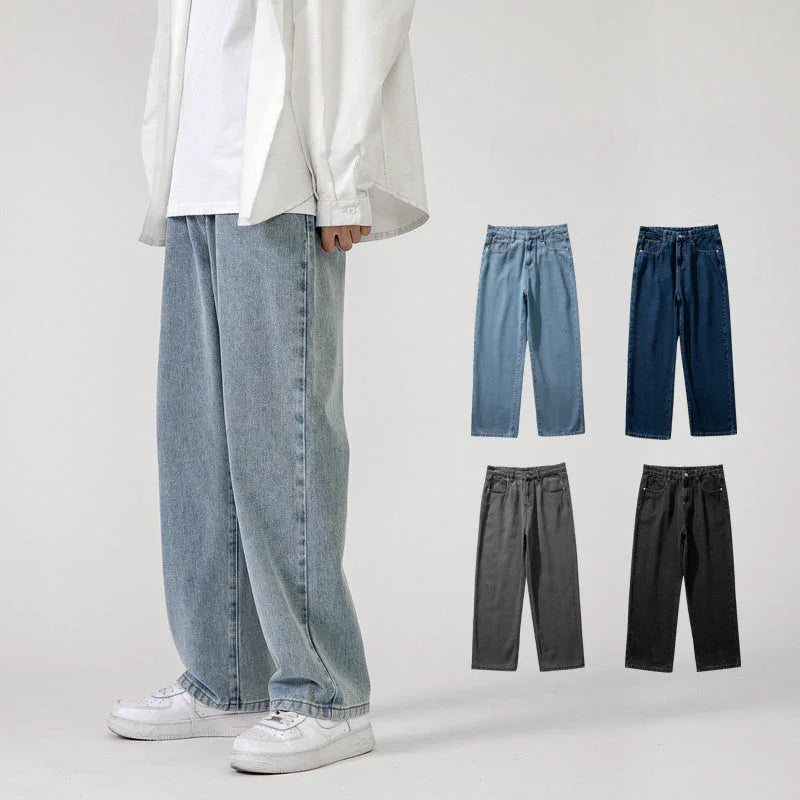 A person wearing Men’s Baggy Jeans with a wide-leg design, white sneakers, a white shirt, and overshirt stands against a plain background. Four additional color options for the jeans are displayed: light blue, dark blue, gray, and black.