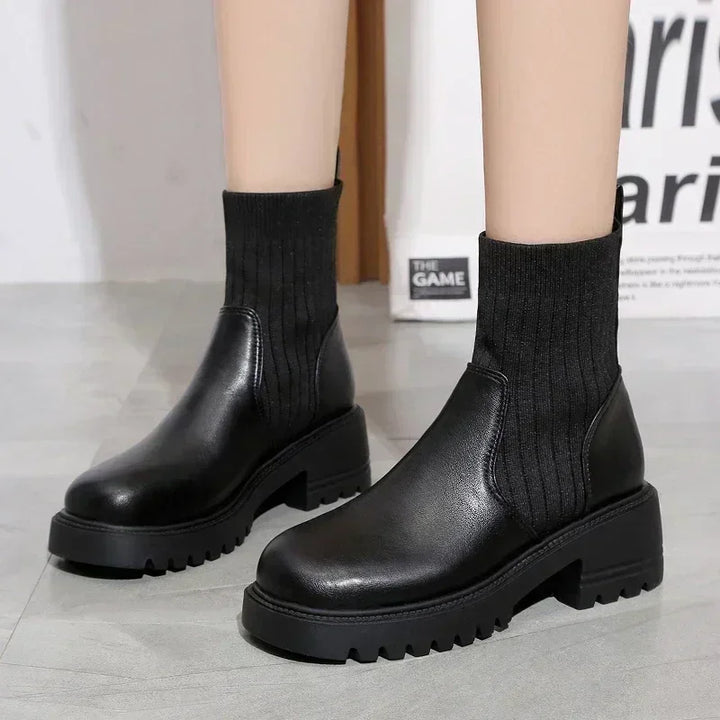 Rovelli black chunky ankle boots with ribbed knit sock detail on light gray floor