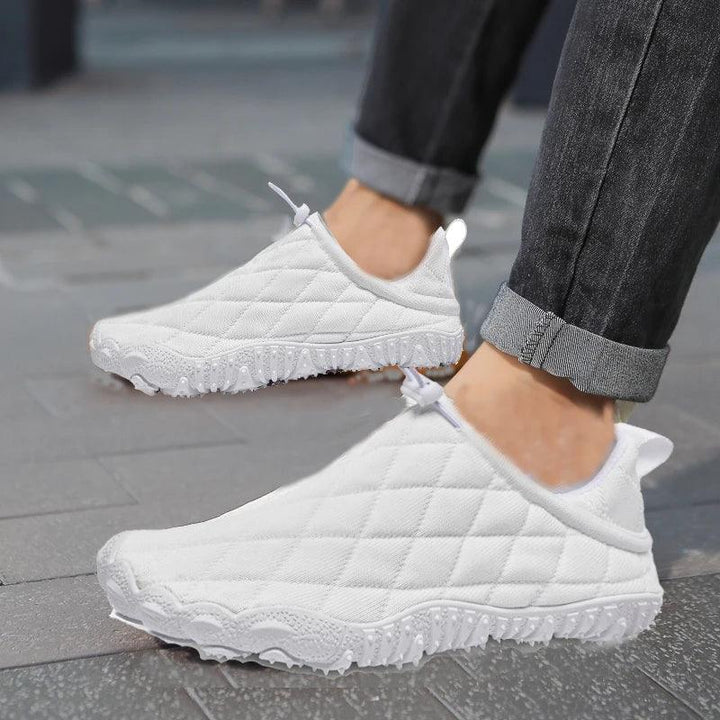 Rovelli white quilted slip-on sneakers with textured soles on a city sidewalk