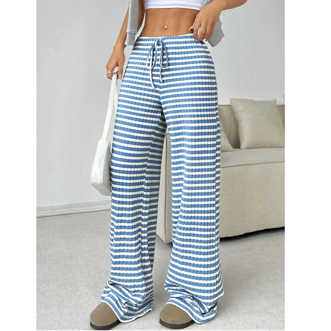 Woman wearing Rovelli blue and white striped wide-leg lounge pants in a modern living room