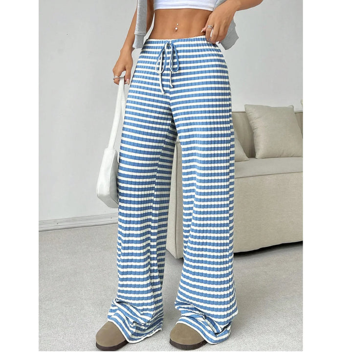 Woman wearing Rovelli blue and white striped wide-leg lounge pants in a modern living room