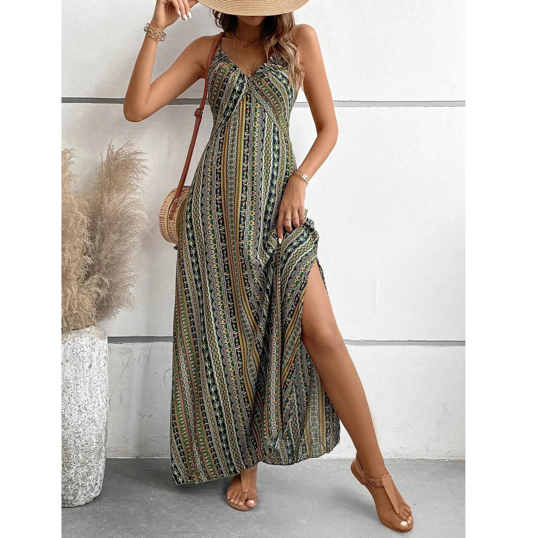 Woman in patterned maxi dress with slit, straw hat, and sandals, standing by pampas grass