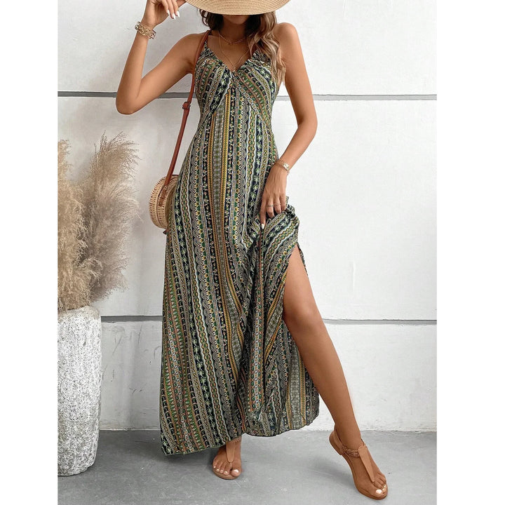 Woman in patterned maxi dress with slit, straw hat, and sandals, standing by pampas grass