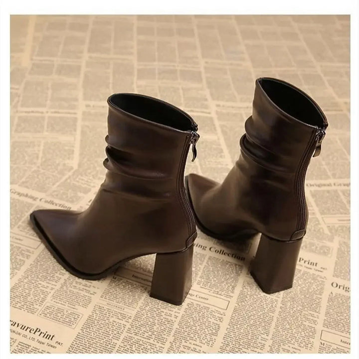 Rovelli dark brown leather ankle boots with block heels on newspaper background