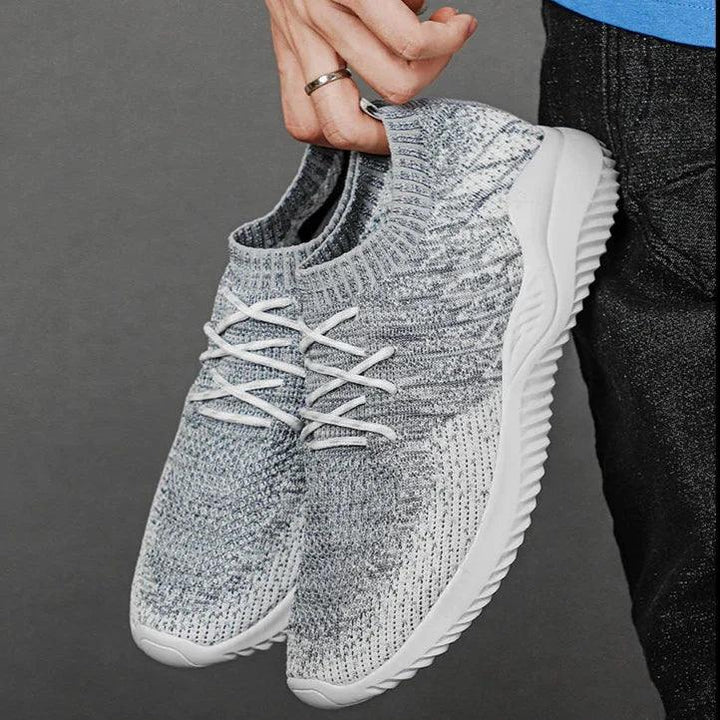 Rovelli gray knit sneakers with white soles, hand-held against a neutral background