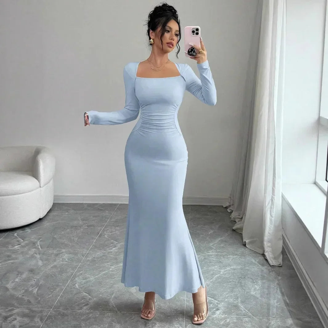 Woman in light blue long sleeve maxi dress taking mirror selfie in modern room, Rovelli fashion