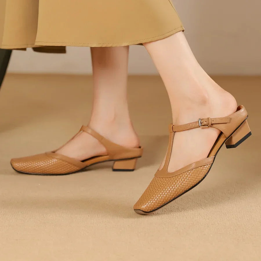 Woman wearing Rovelli tan woven leather low block heel T-strap shoes indoors
