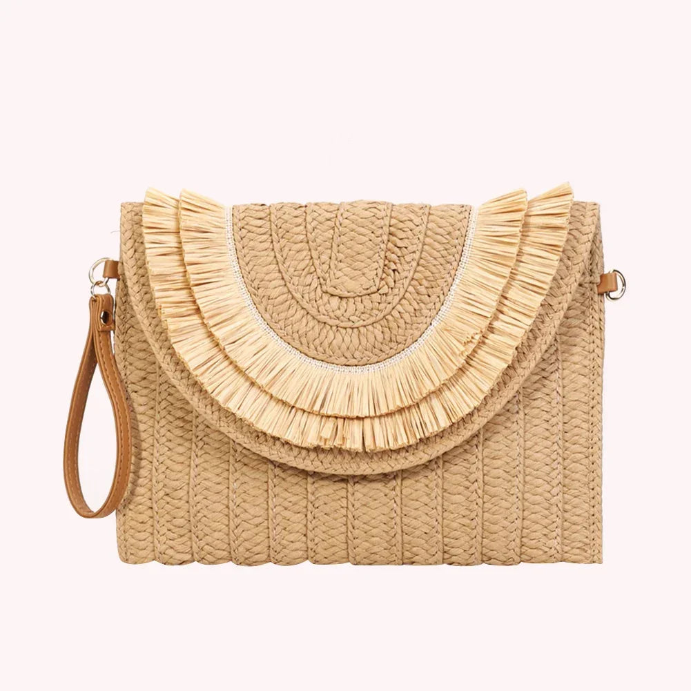 Rovelli woven straw clutch bag with wrist strap and fringe detailing on a light background