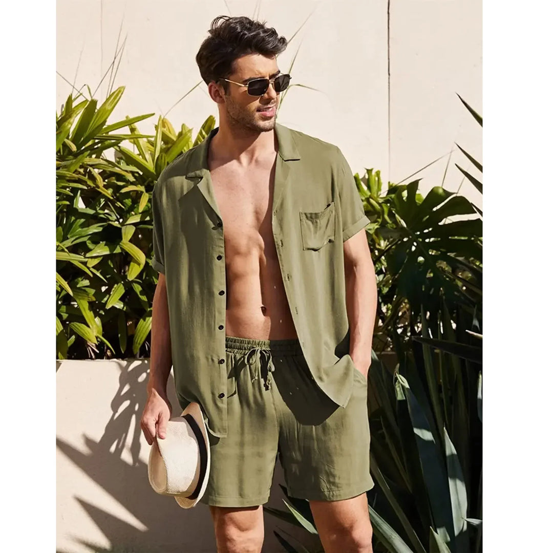 Man in olive green summer shirt and shorts set, sunglasses, holding hat, Rovelli style
