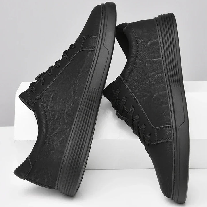 Rovelli classic black low-top sneakers with textured finish and rubber soles on white background