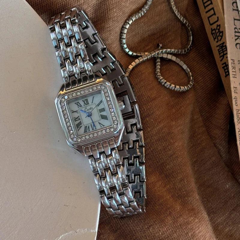 Silver luxury wristwatch with diamond bezel on brown fabric, Rovelli accessory style