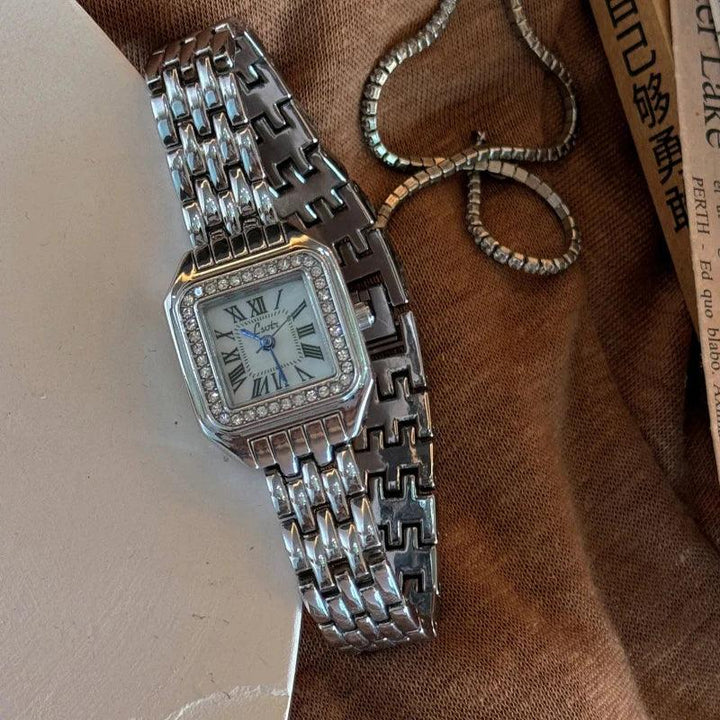 Silver luxury wristwatch with diamond bezel on brown fabric, Rovelli accessory style