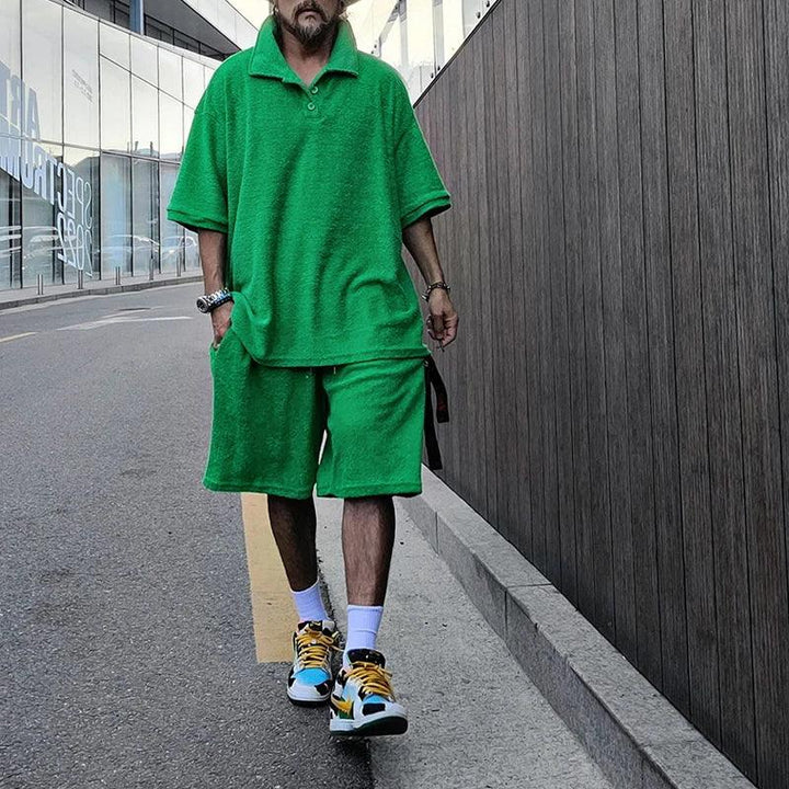 Man wearing bright green matching shirt and shorts set, sneakers, walking on city street, Rovelli fashion