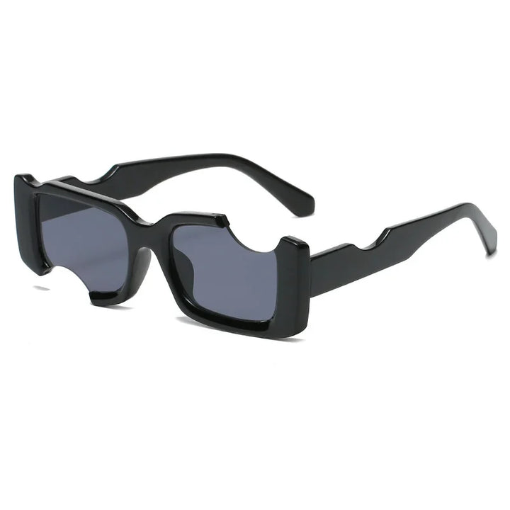 Avant-garde sunglasses with rectangular black, chunky frames and unique cut-out details on the top and sides, featuring dark tinted lenses and UV400 protection.