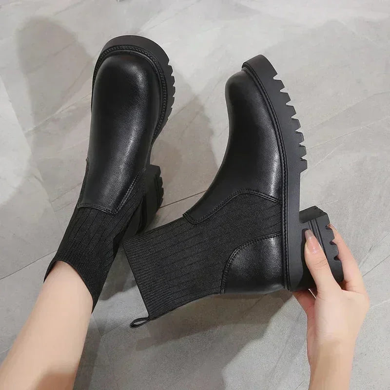 Rovelli black leather ankle boots with ribbed sock detail and chunky sole on gray floor