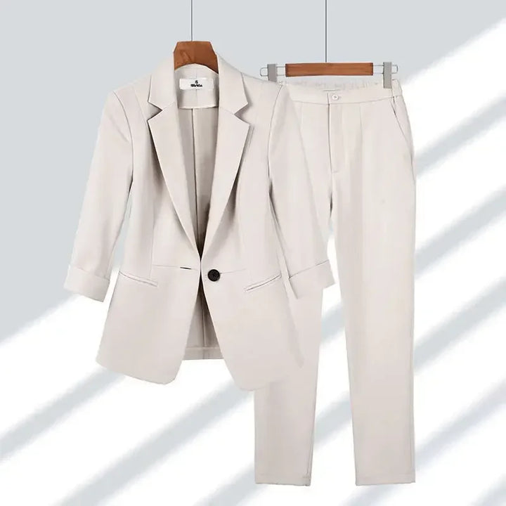 Rovelli women's beige blazer and pants suit set on hangers, modern light background