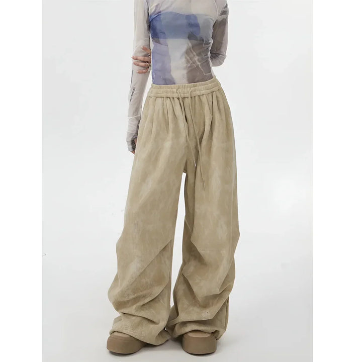 Model wearing wide leg beige corduroy pants and sheer printed top Rovelli fashion
