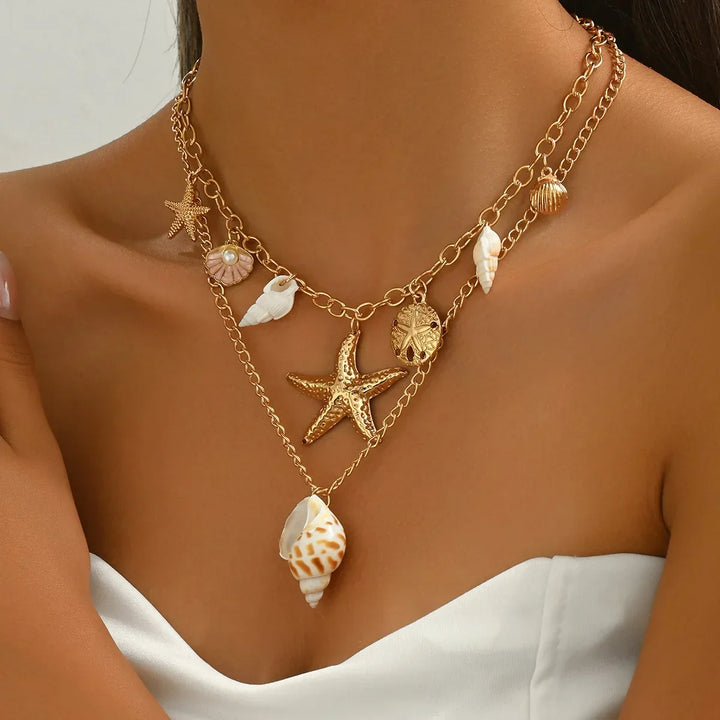 Layered gold chain necklace with starfish, seashell, and pearl charms by Rovelli