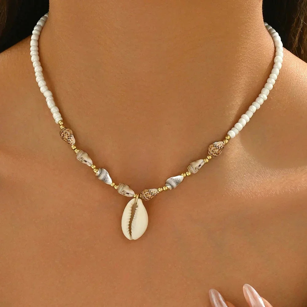 Rovelli seashell beaded necklace with cowrie pendant on woman's neck