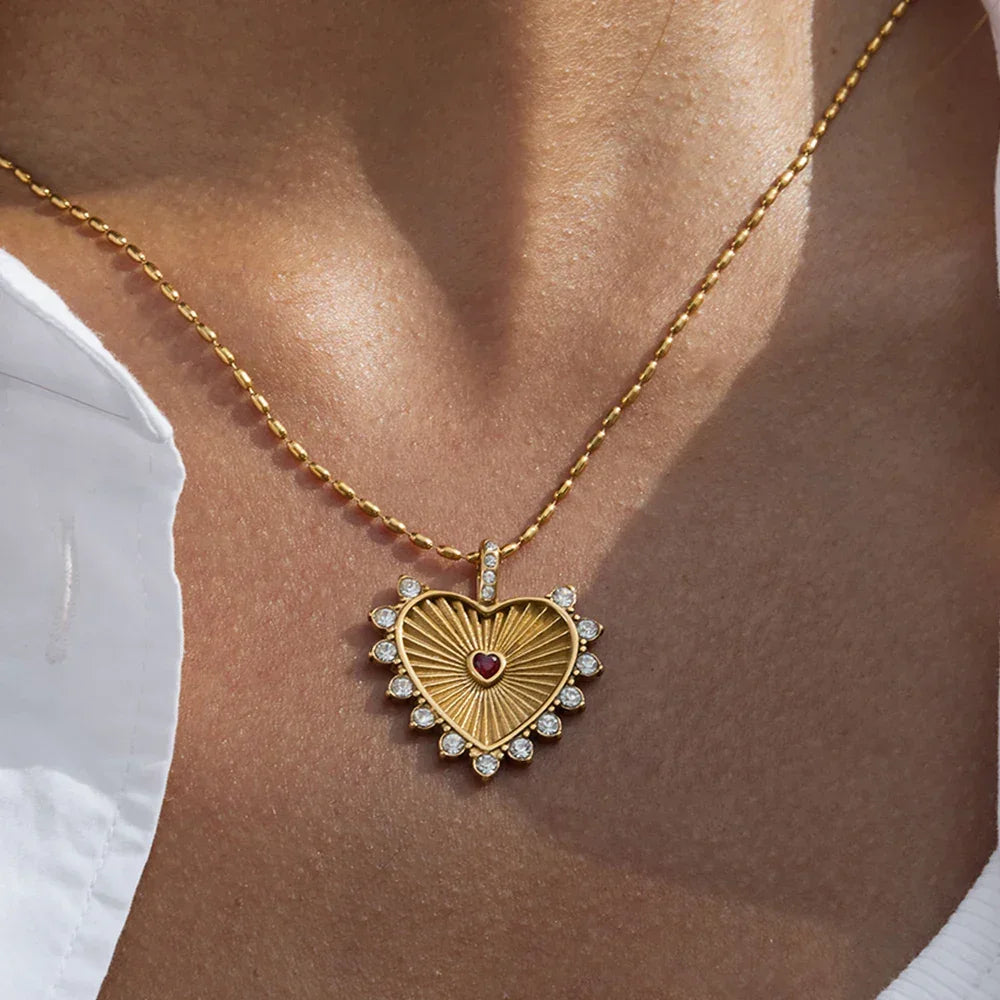 Gold heart-shaped pendant necklace with gemstones, worn on neck, Rovelli jewelry