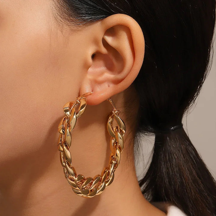 Rovelli chunky gold chain hoop earring on woman's ear, close-up jewelry fashion