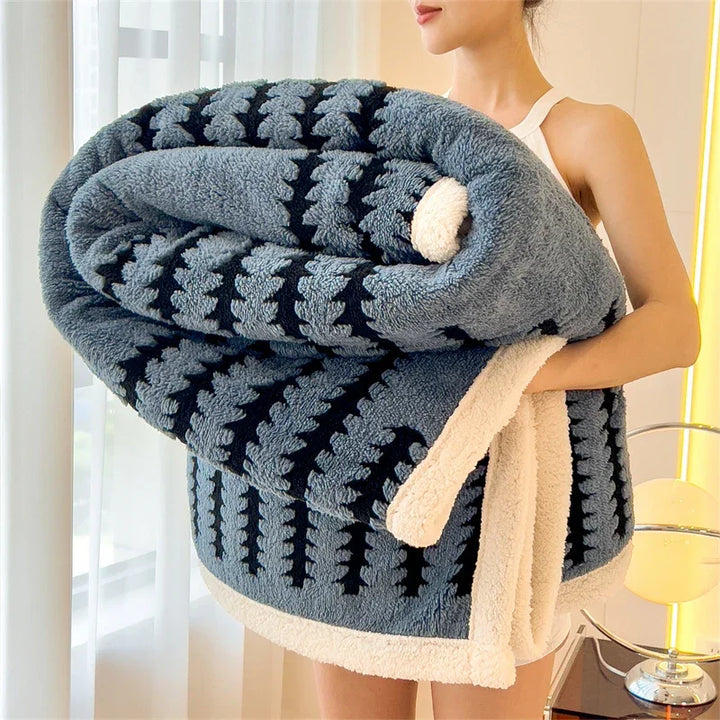 Woman holding large blue and black patterned fluffy blanket with white trim, Rovelli home decor