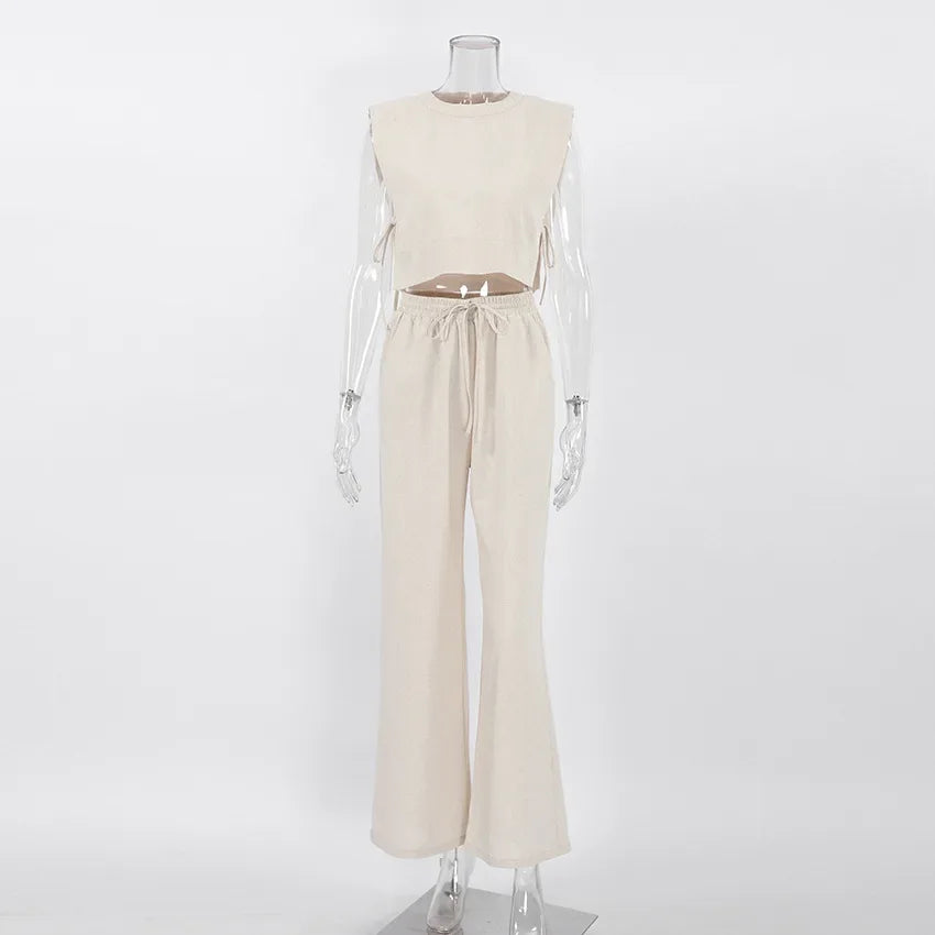 A sleeveless beige cropped top and matching high-waisted, drawstring, wide-leg pants in a Belgian Linen Blend, displayed on a clear mannequin against a plain white background.