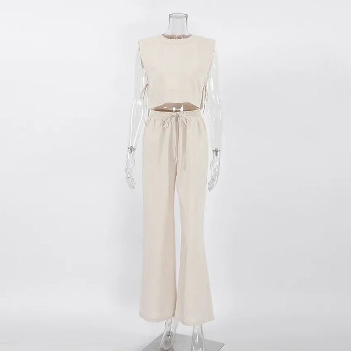 A sleeveless beige cropped top and matching high-waisted, drawstring, wide-leg pants in a Belgian Linen Blend, displayed on a clear mannequin against a plain white background.