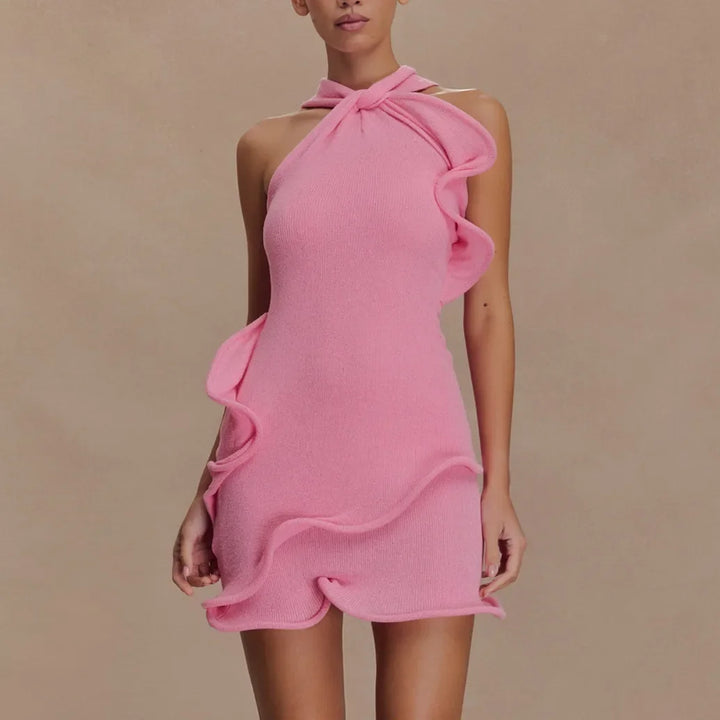 Woman wearing pink ruffled halter neck mini dress by Rovelli, neutral background