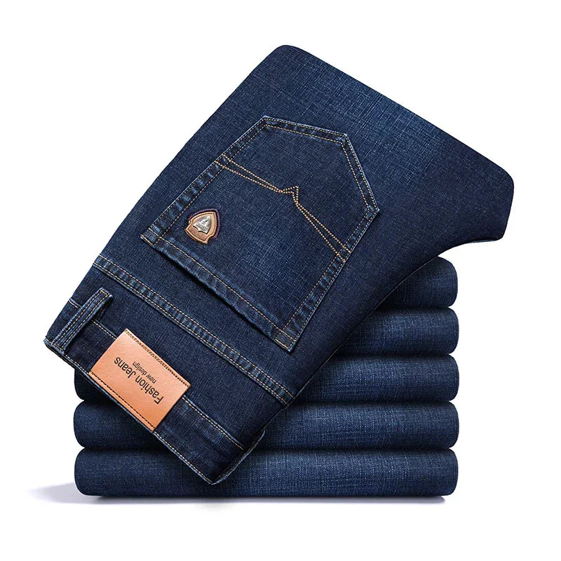 Stack of folded dark blue Rovelli jeans with leather label and back pocket detail