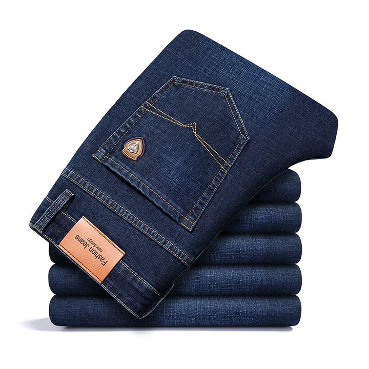 Stack of folded dark blue Rovelli jeans with leather label and back pocket detail