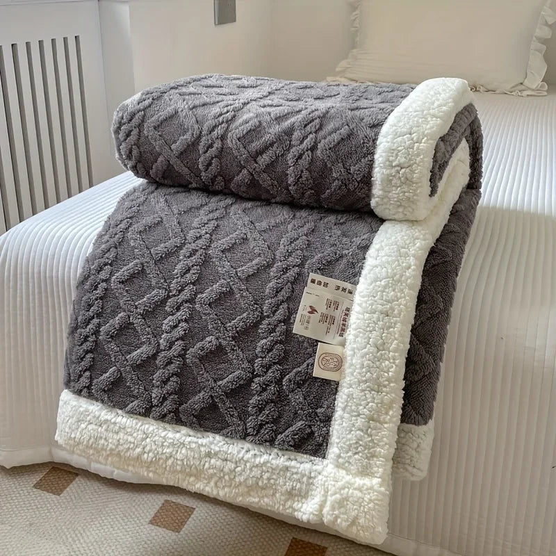 Rovelli grey sherpa throw blanket with diamond pattern and white trim on bed
