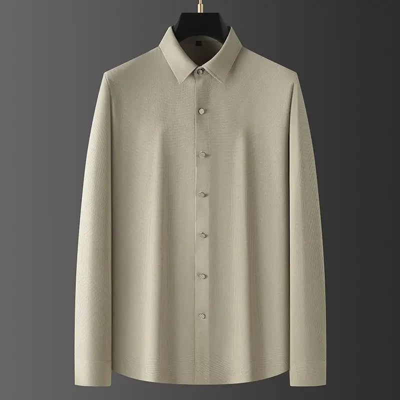 A long-sleeve, light beige wrinkle-resistant shirt with a pointed collar, displayed on a hanger against a dark gray background.