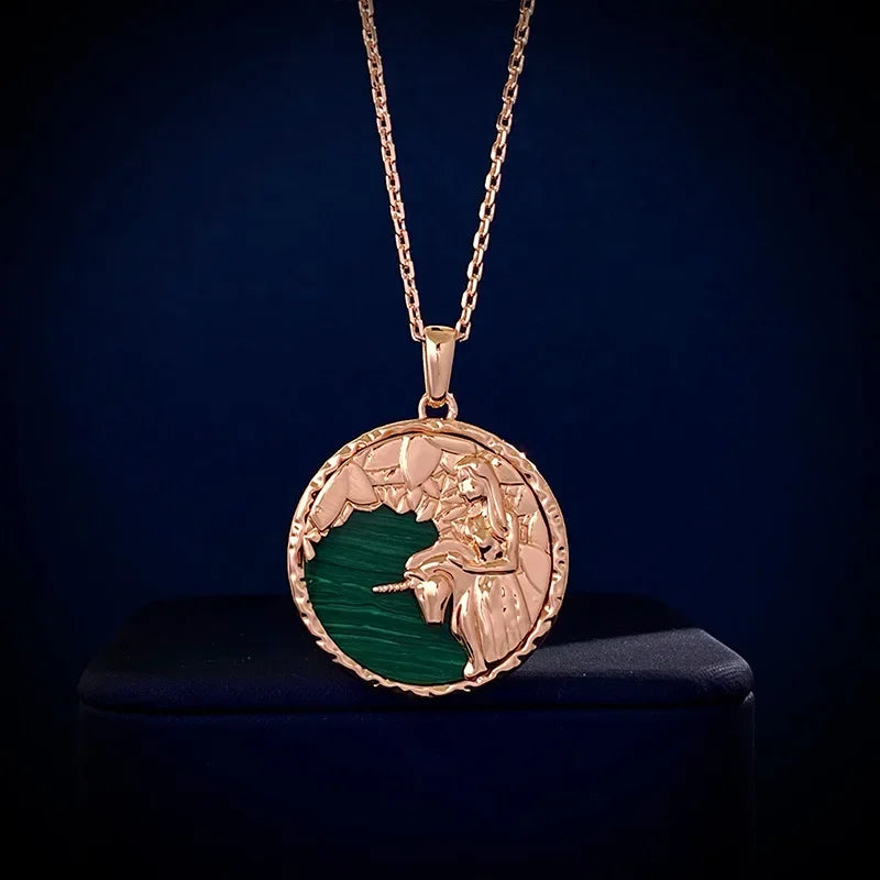 A gold zodiac necklace featuring an engraved lion’s head and mane over a green background, displayed against a dark blue setting—a striking piece of astrology jewelry.
