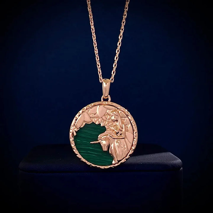A gold zodiac necklace featuring an engraved lion’s head and mane over a green background, displayed against a dark blue setting—a striking piece of astrology jewelry.