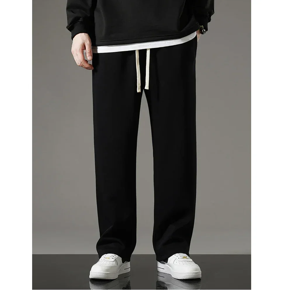 Rovelli black casual pants with drawstring and white sneakers on a model