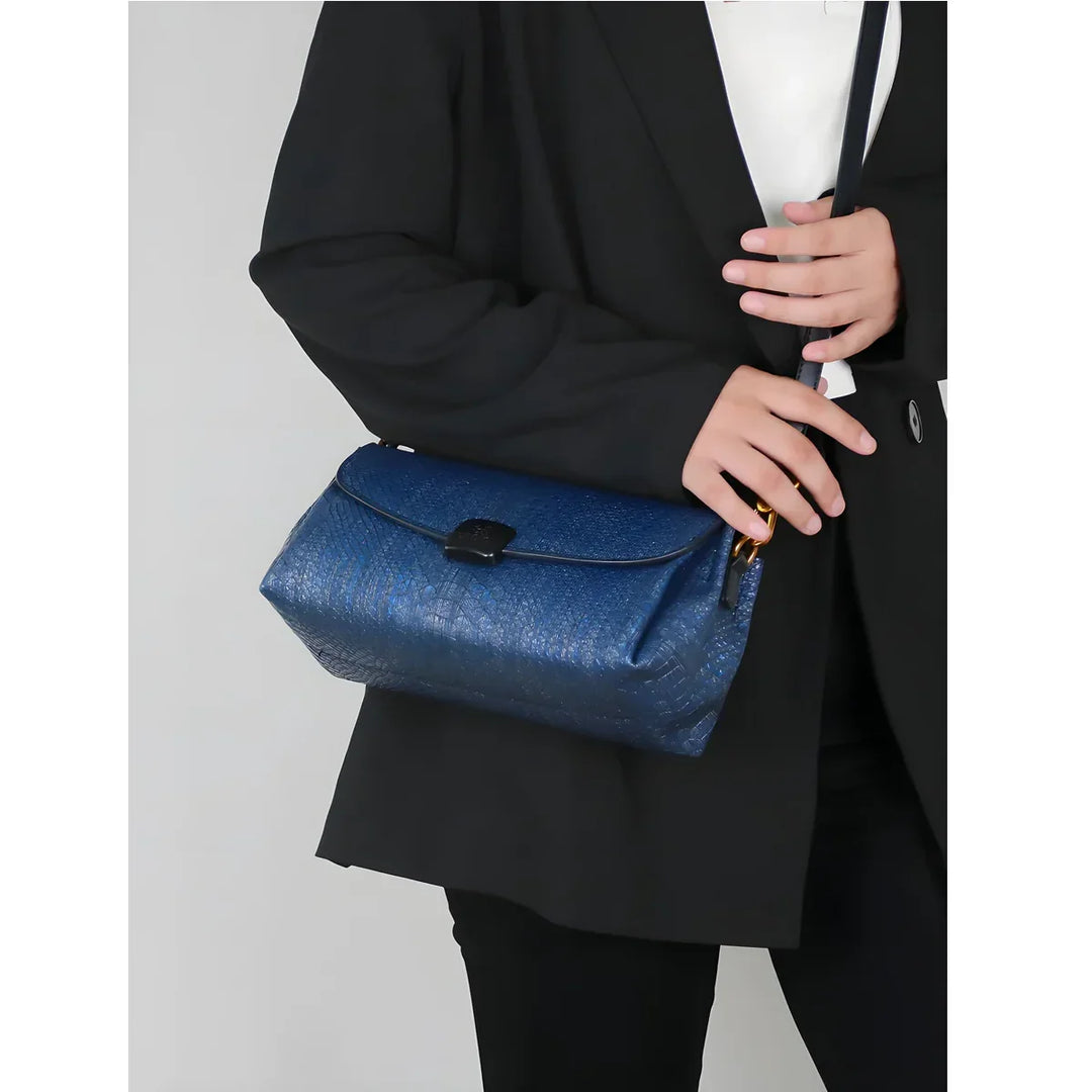 Woman in black blazer holding Rovelli blue textured shoulder bag