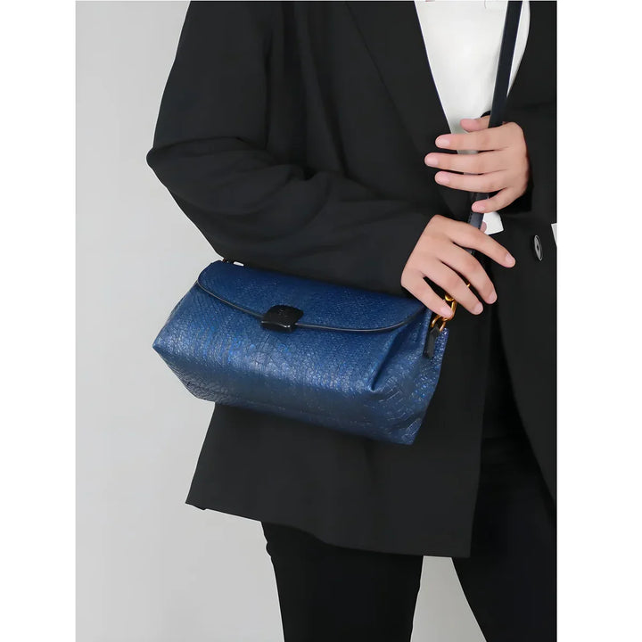 Woman in black blazer holding Rovelli blue textured shoulder bag