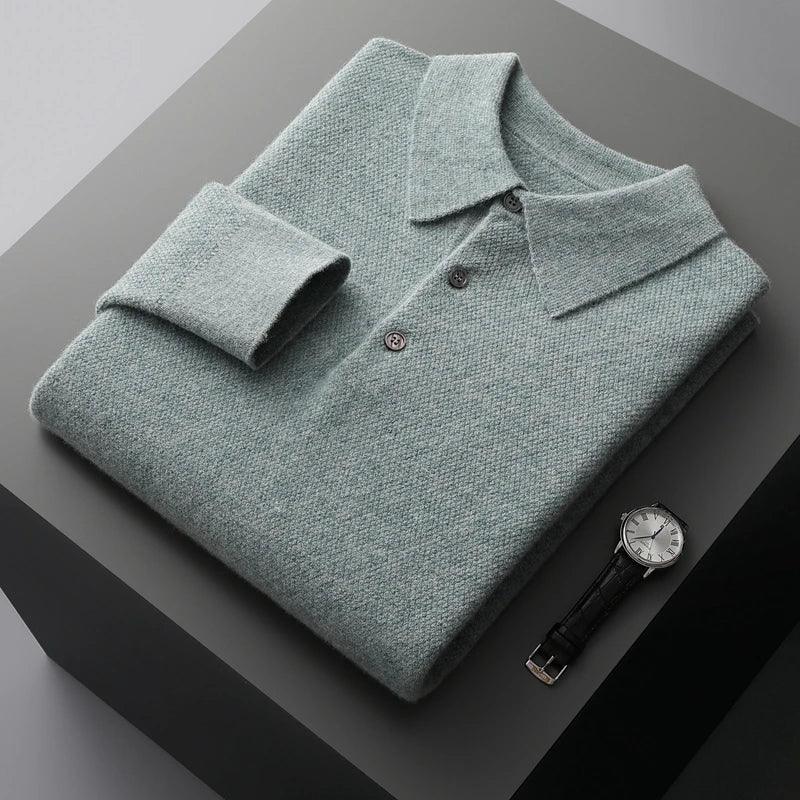 Folded grey knit polo shirt with buttons next to a wristwatch on a grey surface, Rovelli style