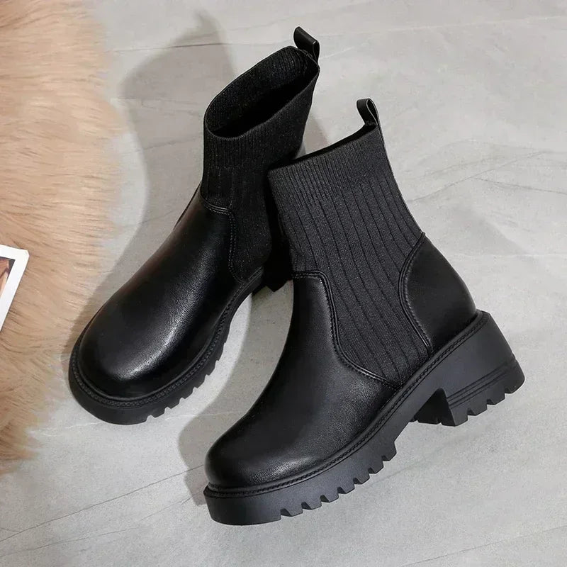 Rovelli black ankle boots with ribbed knit shaft and chunky sole on gray floor