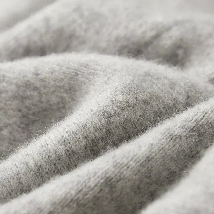 Close-up view of soft, light gray, fuzzy fabric with visible fibers and gentle folds, suggesting warmth and comfort—perfect for comfortable pants made with durable construction.