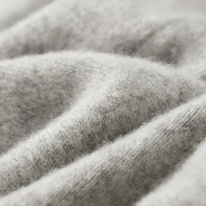 Close-up view of soft, light gray, fuzzy fabric with visible fibers and gentle folds, suggesting warmth and comfort—perfect for comfortable pants made with durable construction.