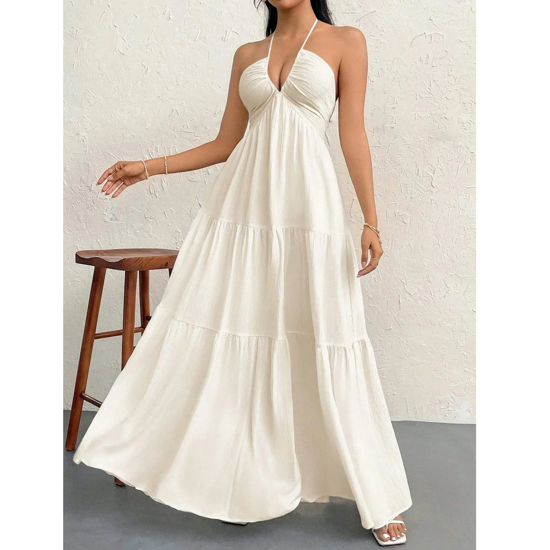 Woman wearing elegant white halter maxi dress in minimalist setting, Rovelli fashion