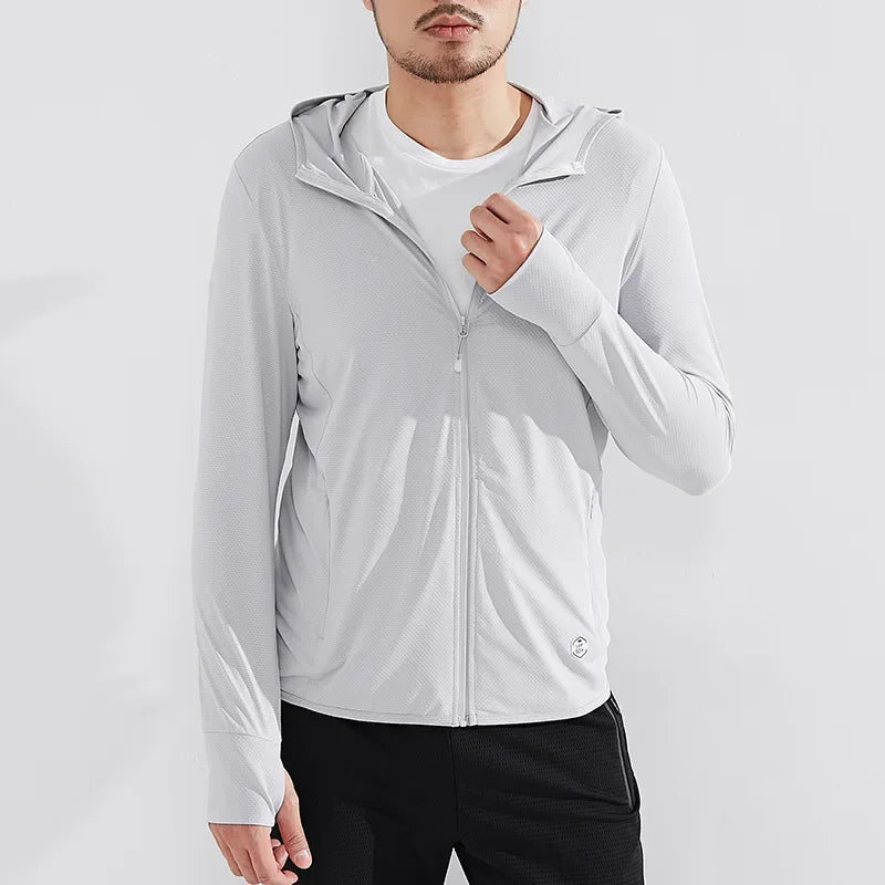 A man wearing a light gray zip-up hoodie with UPF 50+ sun protection over a white t-shirt and black pants stands against a plain white background. The hoodie features a hood, thumb holes on the sleeves, and quick-drying fabric.