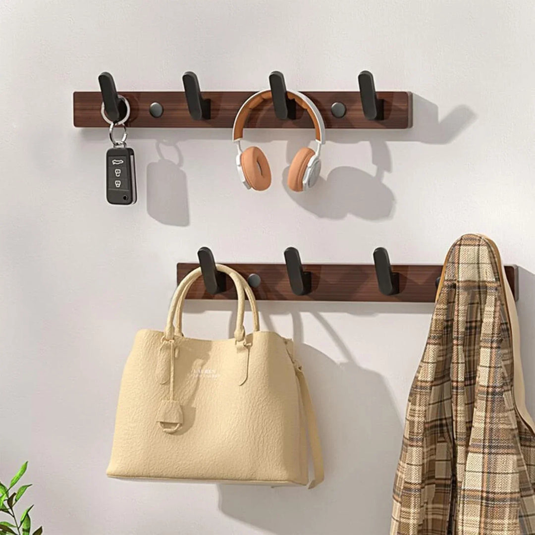 Modern wall hooks with a beige handbag, plaid coat, headphones, and car keys, Rovelli decor