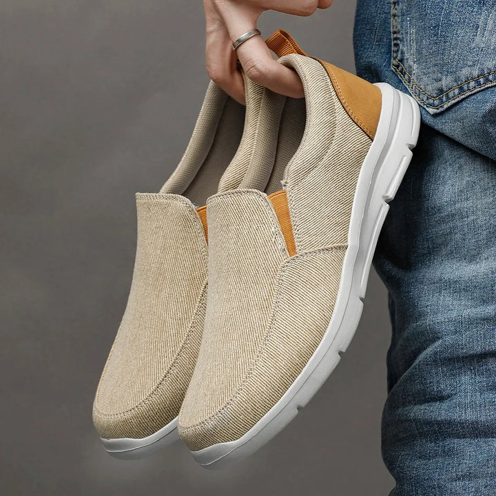 Rovelli beige canvas slip-on shoes with white soles held by hand, casual style
