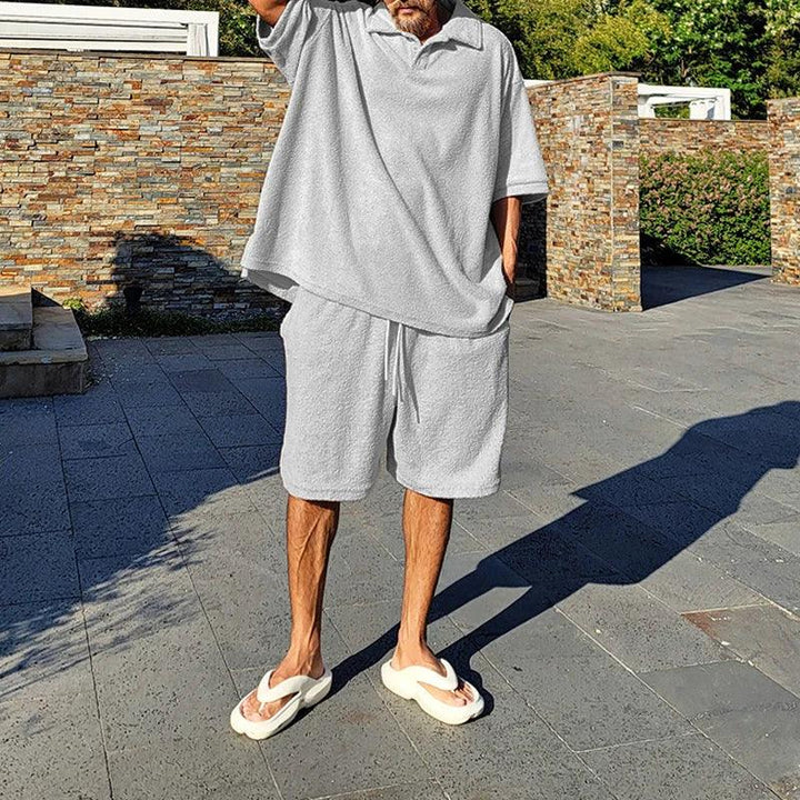 Man wearing light gray terry cloth lounge set and white slides outdoors, Rovelli fashion