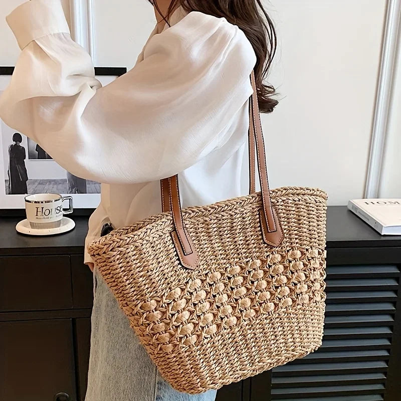 Woman carrying woven straw tote bag with leather straps, Rovelli fashion accessory